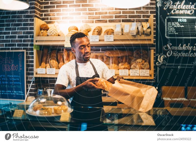 African man works in pastry shop. Bread Blackboard Work and employment Profession Business Human being Man Adults Smiling Stand Sell Happiness Bakery Storage