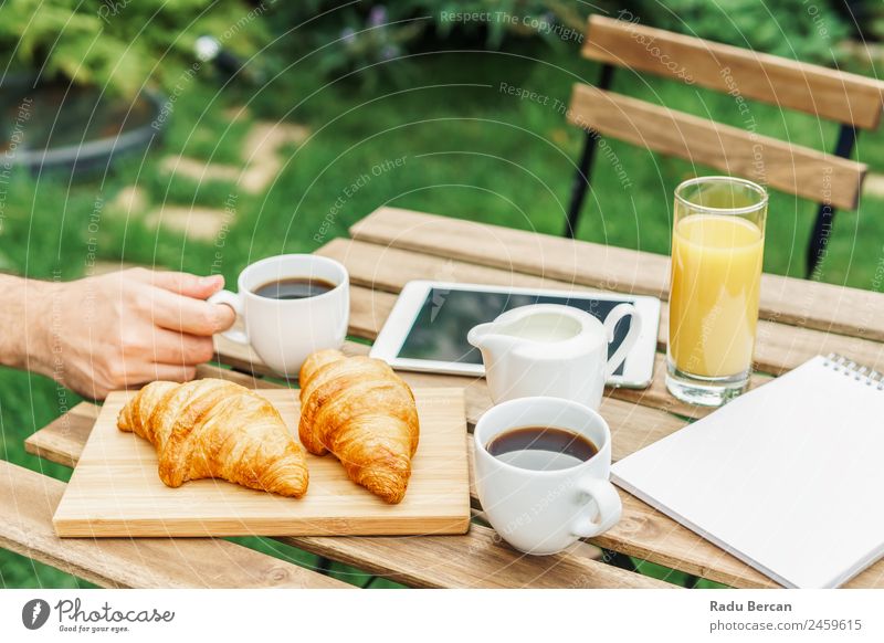 Morning Breakfast In Green Garden With French Croissant, Coffee Cup, Orange Juice, Tablet and Notes Book On Wooden Table Background picture White Food Drinking