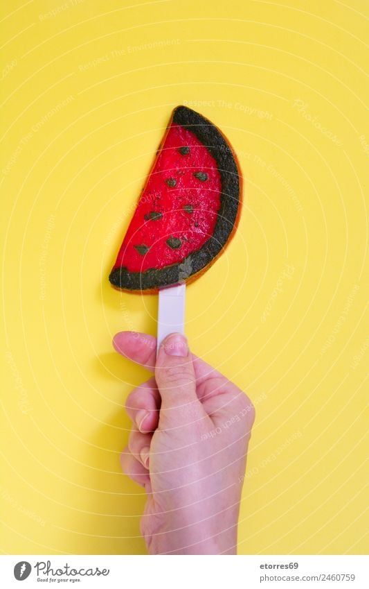 Hand holding watermelon popsicle on yellow background. Top view Food Fruit Dessert Ice cream Candy Eating Organic produce Yellow Red Water melon Summer Snack