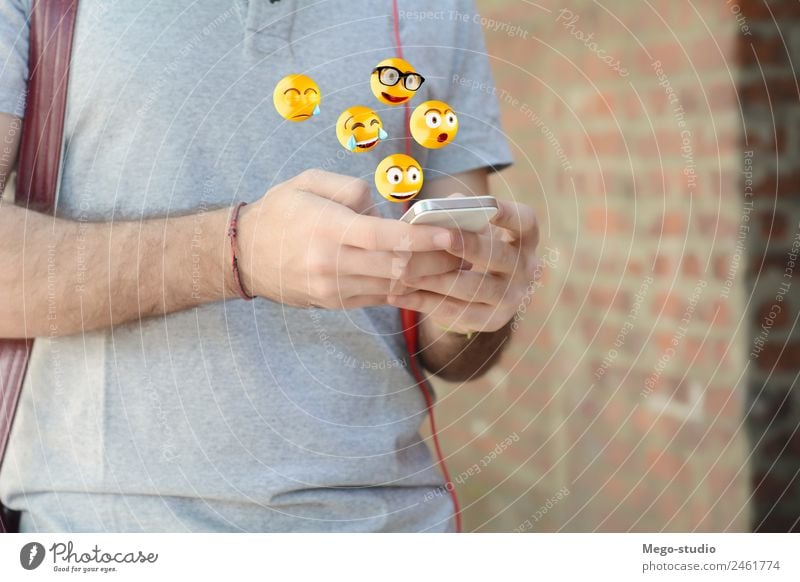 man using smartphone sending emojis. Lifestyle Happy Face Telephone PDA Screen Technology Internet Human being Man Adults Hand Funny Modern Smart Emotions young