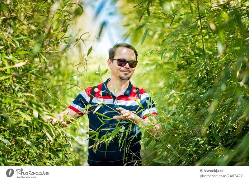Portrait of a young man in the bamboo jungle Portrait photograph Young man 1 Person Sunglasses Green Nature Day Bamboo Bushes Leaf Forest Virgin forest