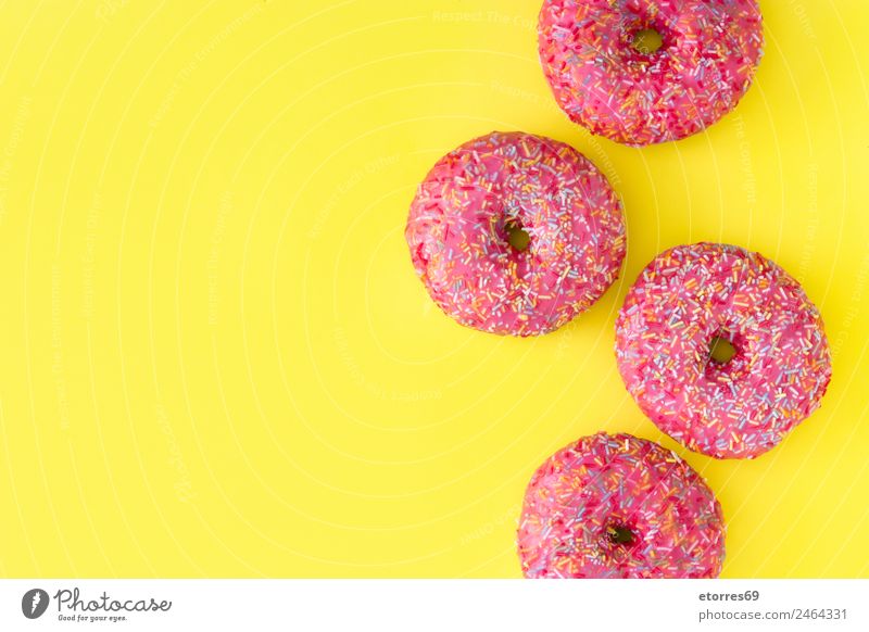 Pink frosted donut Food Roll Dessert Candy Breakfast Yellow Multicoloured Cake Baked goods Icing Hole Snack Tasty Bakery Fast food Colour photo Studio shot
