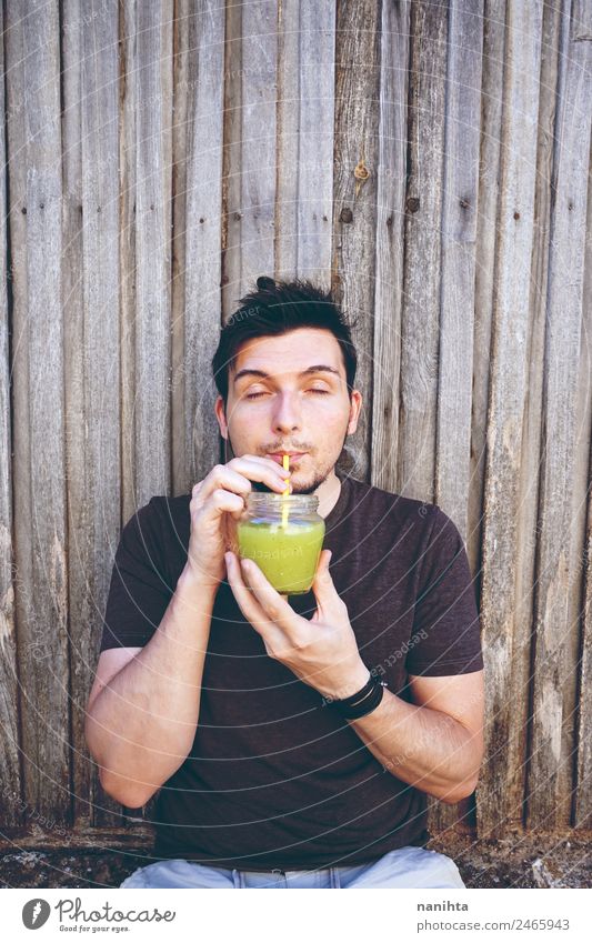 Young man drinking vegetable juice Organic produce Vegetarian diet Beverage Drinking Cold drink Juice Milkshake Glass Straw Lifestyle Style Healthy Eating