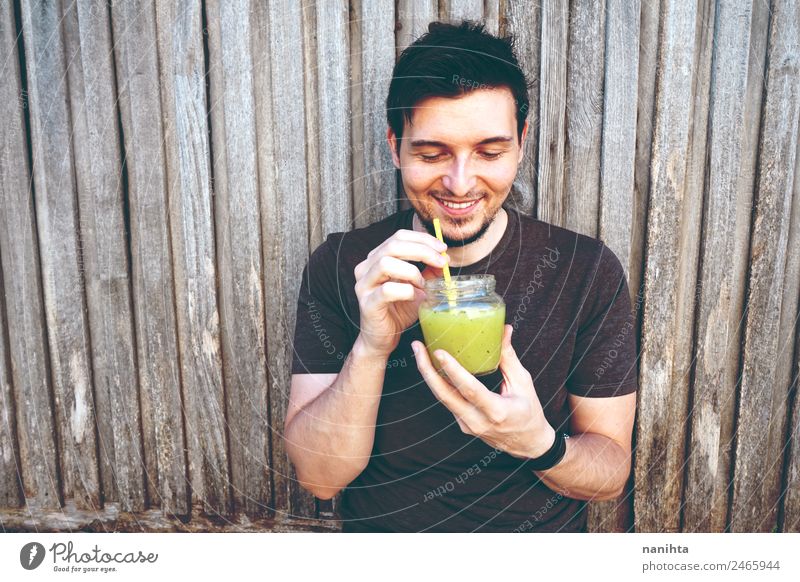 Young happy man enjoying a green smoothie Organic produce Vegetarian diet Beverage Drinking Cold drink Lemonade Juice Milkshake Lifestyle Style Joy Healthy