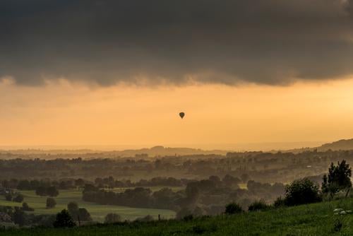 Float away into evening light; hot air balloon in evening sky Adventure Far-off places Freedom Summer Balloon flight Landscape Sky Clouds Tree Grass Meadow
