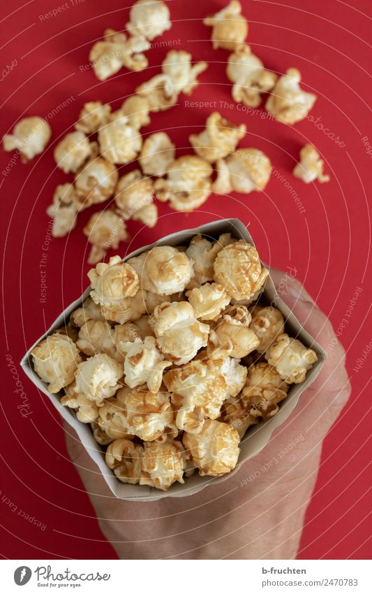 Popcorn in a bag Candy Feasts & Celebrations Man Adults Hand Eating To hold on Happiness Paper bag Cinema Maize Sweet Colour photo Interior shot Studio shot