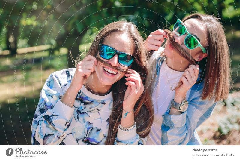 Women doing moustaches with hair and laughing Lifestyle Joy Happy Beautiful Leisure and hobbies Summer Mountain Human being Woman Adults Friendship Couple