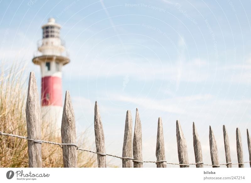 lighthouse romance Grass Coast North Sea Deserted Tower Lighthouse Tourist Attraction Landmark Blue Red White Wanderlust Safety Fence Wooden stake Dune