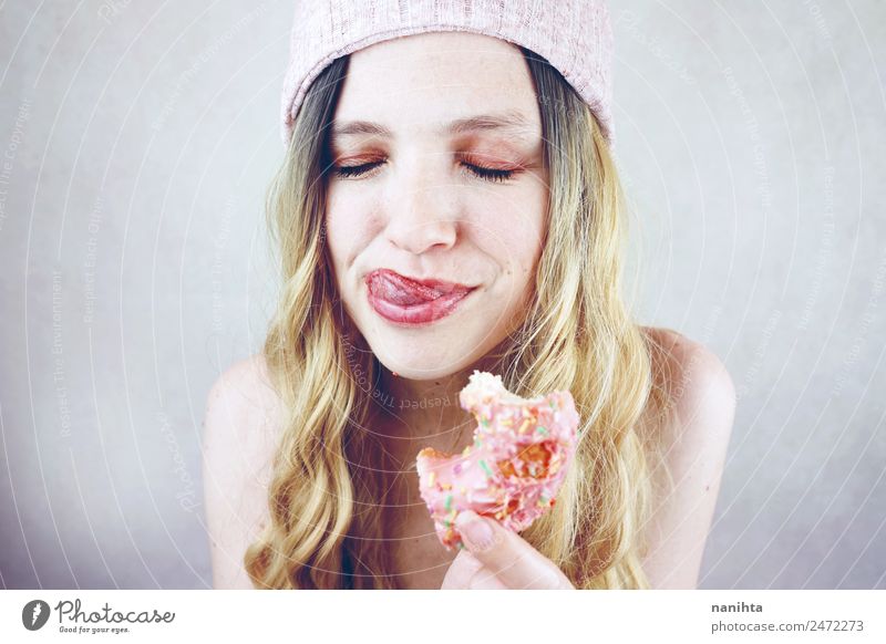 Young blonde woman enjoying a donut Food Dessert Candy Donut Unhealthy Eating Fast food Lifestyle Style Joy Hair and hairstyles Face Wellness Human being