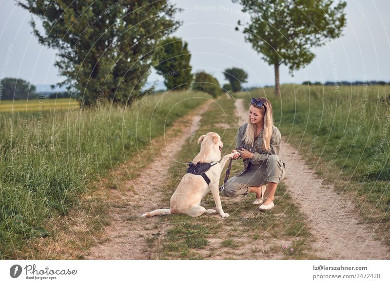 Loving young woman offered a paw by her dog Summer Woman Adults Friendship Landscape Animal Lanes & trails Blonde Dog Paw Gold Labrador Rural Copy Space
