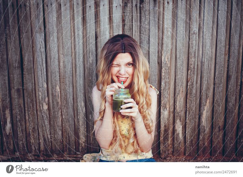 Young happy woman drinking a green smoothie Vegetable Beverage Drinking Cold drink Juice Milkshake Lifestyle Style Joy Beautiful Hair and hairstyles