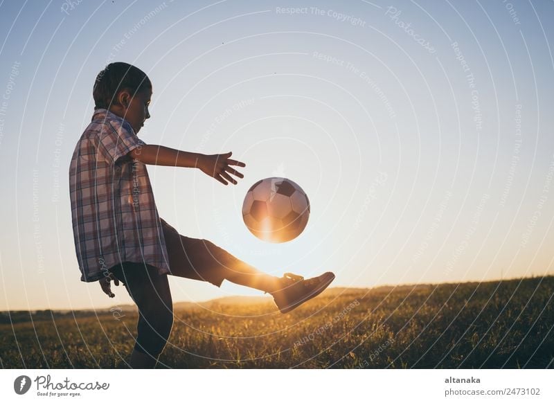 Young little boy playing in the field with soccer ball. Concept of sport. Lifestyle Joy Happy Relaxation Leisure and hobbies Playing Summer Sports Soccer Child