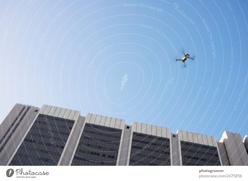 Drone in the sky Office Media industry Aviation Environment Air Sky Town High-rise Architecture Facade Window Aircraft Flying Blue Gray White Colour photo