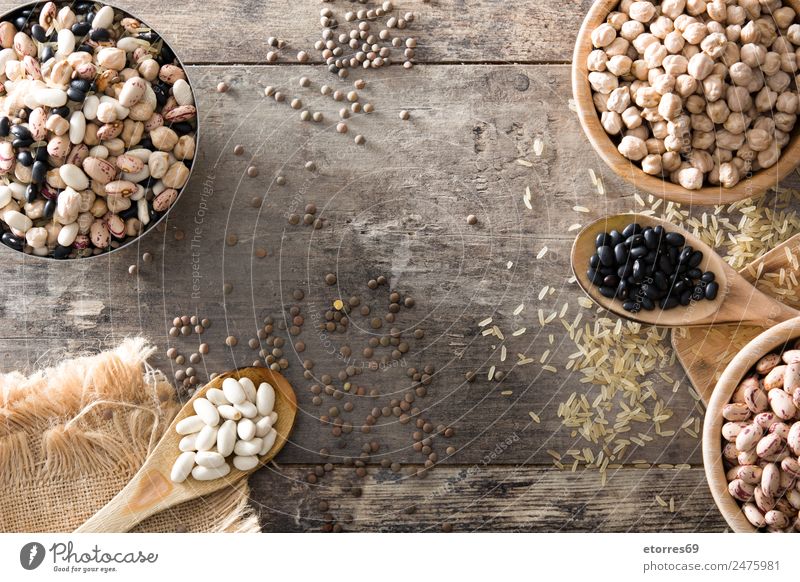 Uncooked assorted legumes in wooden bowl Food Grain Nutrition Organic produce Vegetarian diet Diet Bowl Spoon Natural Brown Black White Legume Beans Chickpeas