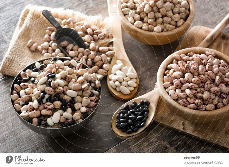 Uncooked assorted legumes in wooden bowl Food Grain Nutrition Organic produce Vegetarian diet Diet Bowl Spoon Natural Brown Black White Legume Beans