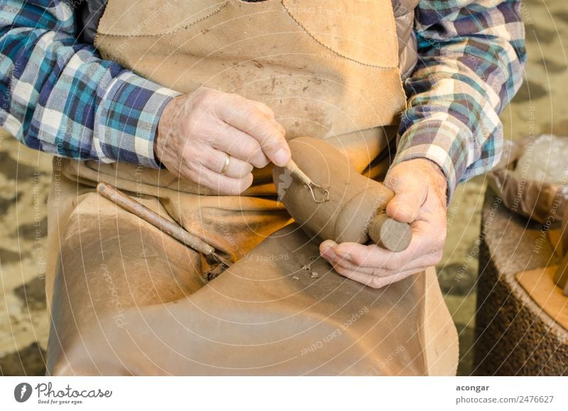 Old hands of a potter shaping a clay figure Handicraft Work and employment Profession Craftsperson Tool 60 years and older Senior citizen Art Artist Brown