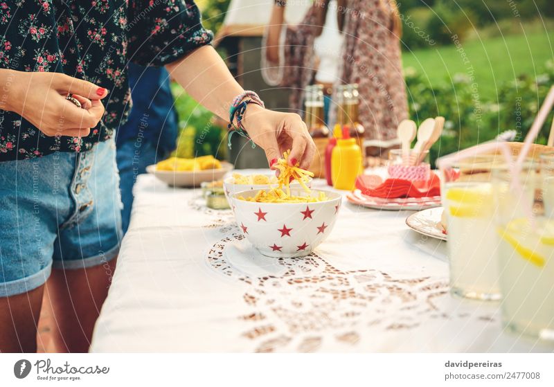 Woman hand taking chips potatoes from bowl Bread Lemonade Alcoholic drinks Beer Plate Bowl Lifestyle Joy Leisure and hobbies Summer Garden Table Adults Man