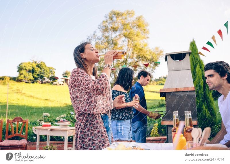Woman drinking beer in a barbecue with friends Meat Lunch Drinking Alcoholic drinks Beer Bottle Lifestyle Joy Happy Leisure and hobbies Summer Garden Table