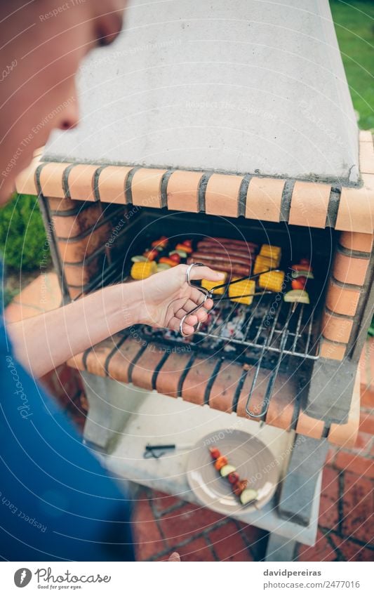 Unrecognizable young man cooking meal in barbecue Sausage Vegetable Lifestyle Joy Happy Relaxation Summer Garden Human being Man Adults Friendship Hand Nature