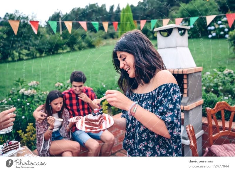 Woman eating piece of cake in summer party Eating Plate Spoon Lifestyle Joy Happy Leisure and hobbies Summer Garden To talk Adults Man Friendship Group Nature