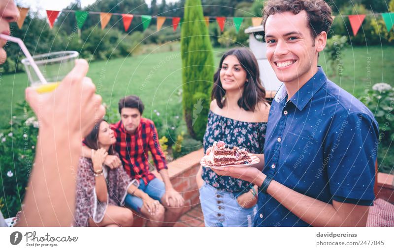 Man with piece of cake in a summer barbecue Lunch Lemonade Plate Lifestyle Joy Happy Leisure and hobbies Summer Garden To talk Woman Adults Friendship Group