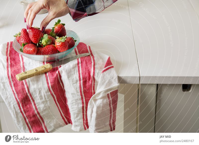 woman picking strawberries, a glass bow Food Meat Fruit Nutrition Breakfast Diet Bowl Lifestyle Beautiful Table Human being Woman Adults Hand Nature Sit Fresh