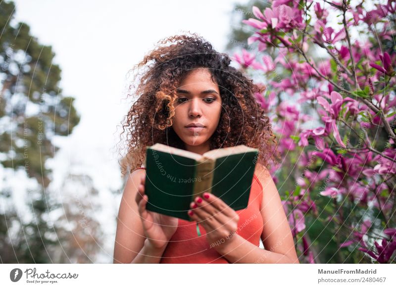 afro woman reading a book outdoors Lifestyle Happy Beautiful Leisure and hobbies Reading Summer Garden School Study Human being Woman Adults Book Nature Tree