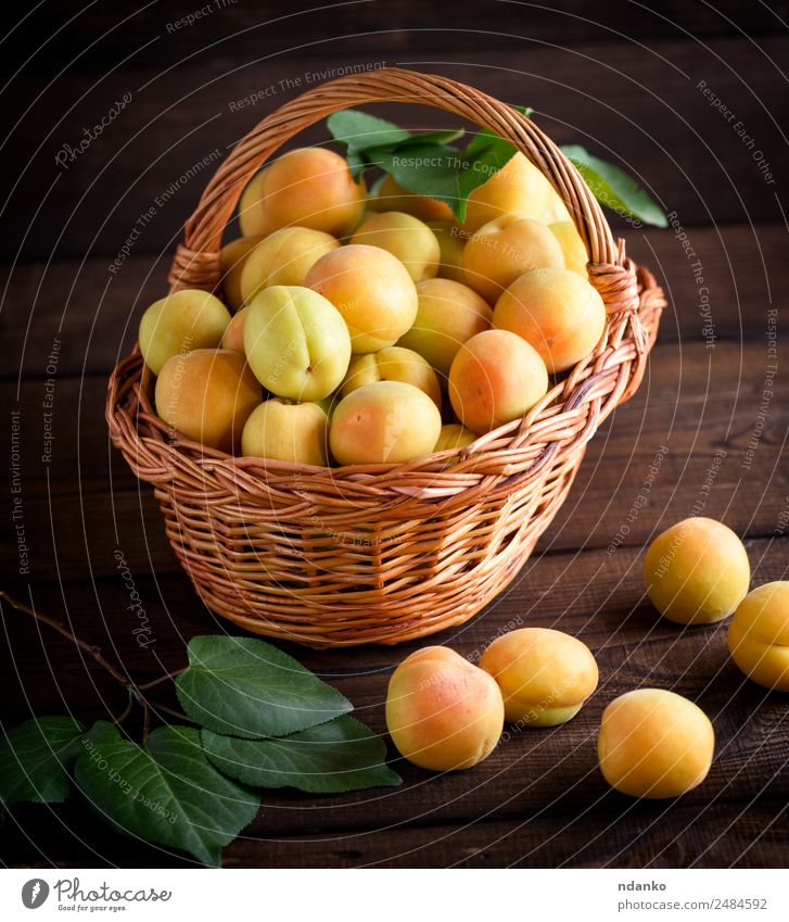 Ripe yellow apricots Fruit Nutrition Vegetarian diet Diet Table Nature Leaf Wood Fresh Natural Juicy Brown Yellow Colour Basket agriculture Apricot background