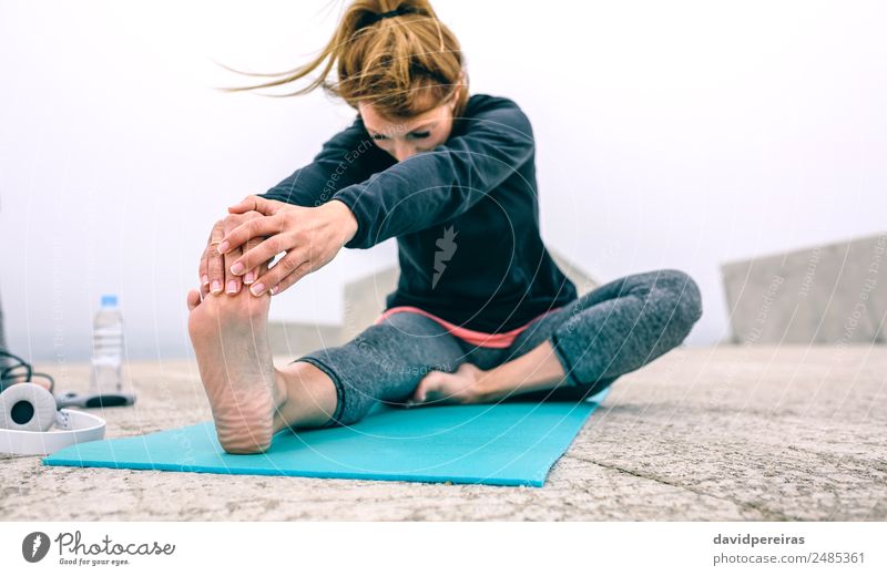Young woman stretching legs by sea pier Bottle Lifestyle Beautiful Wellness Calm Winter Sports Yoga Human being Woman Adults Hand Feet Fog Concrete Fitness