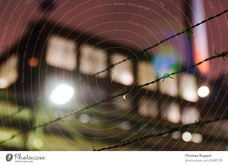 In the evening Sky Night sky Industrial plant Factory Facade Window Chimney Lamp Street lighting Fence Barbed wire Barbed wire fence Multicoloured Colour photo