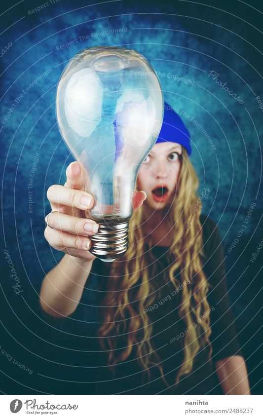 Young woman holding a huge light bulb Lifestyle Style Design Hair and hairstyles Leisure and hobbies Technology Science & Research Advancement Future