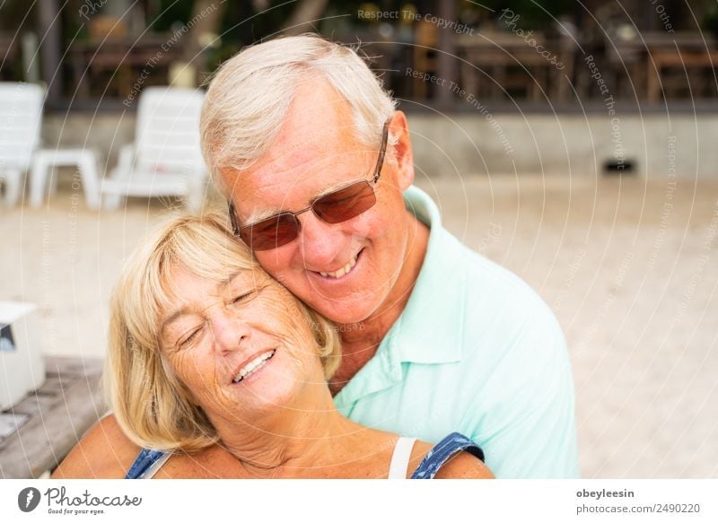 Older couple sit together at the beach. Lifestyle Joy Happy Calm Leisure and hobbies Vacation & Travel Summer Sun Beach Ocean Human being Woman Adults Man