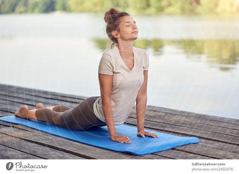 Attractive woman working out on a wooden deck Lifestyle pretty Body Wellness Relaxation Meditation Yoga Woman Adults 1 Human being Lake Fitness White Energy