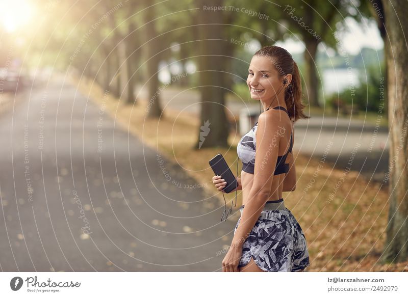 Attractive sporty woman with her cell phone Lifestyle Body Face Summer Music Sports Jogging Telephone PDA Camera Woman Adults 1 Human being 18 - 30 years