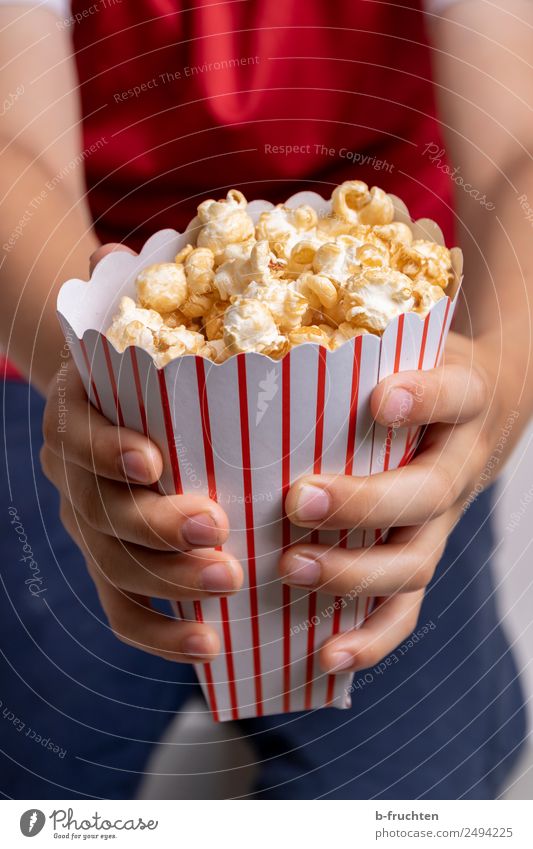 A bag of popcorn Candy Fast food Entertainment Boy (child) Hand Fingers 3 - 8 years Child Infancy Event Television To hold on Fresh Sweet Popcorn Paper bag