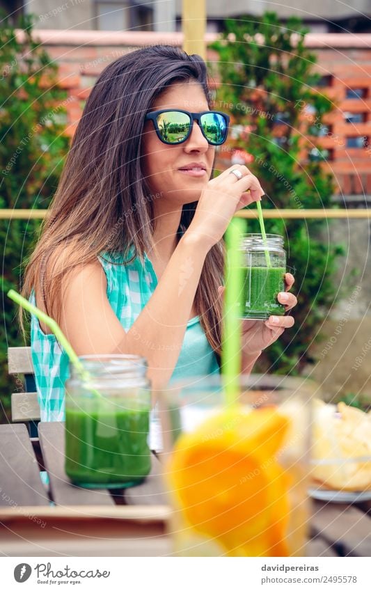 Woman with sunglasses drinking green vegetable smoothie outdoors Vegetable Fruit Nutrition Diet Beverage Juice Lifestyle Happy Beautiful Summer Human being
