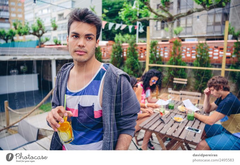 Young man drinking infused water cocktail outdoors Fruit Beverage Juice Lifestyle Joy Happy Leisure and hobbies Summer Garden Table Human being Woman Adults Man