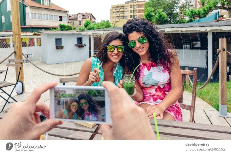 Man hands taking photo with smartphone to two happy young women Vegetable Fruit Beverage Juice Lifestyle Happy Summer Telephone PDA Technology Human being Woman