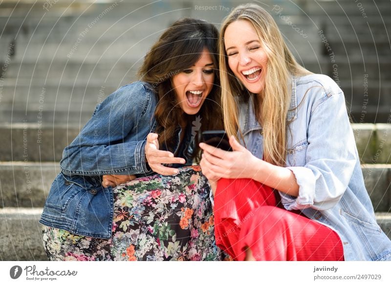 Two women laughing looking at their smart phone Lifestyle Shopping Joy Happy Beautiful Telephone PDA Technology Human being Feminine Young woman