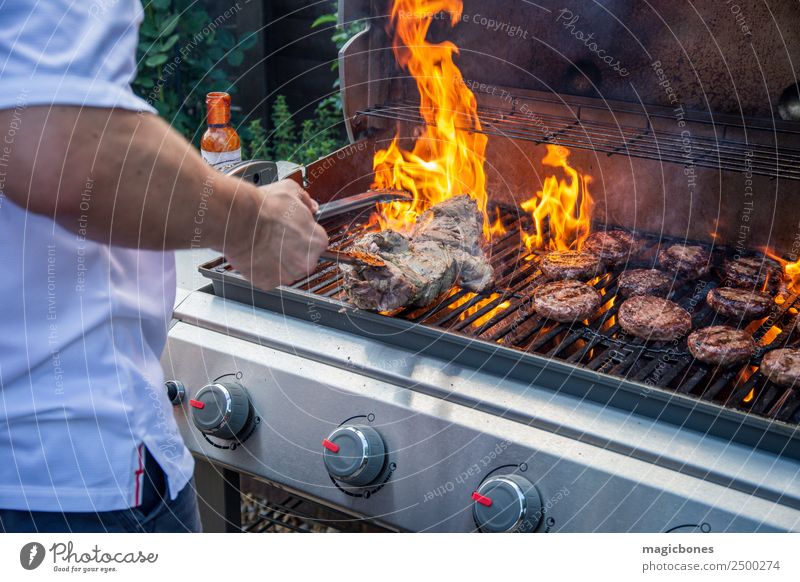 Man cooking on a barbecue Meat Herbs and spices Summer Garden Hot Delicious BBQ Grilling Backyard barbecuing barbeque beef burger beefburger Blaze blazing