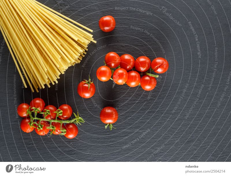 long pasta and ripe red cherry tomatoes Vegetable Dough Baked goods Lunch Eating Fresh Large Long Above Yellow Red Black Colour Tradition Spaghetti food Tomato