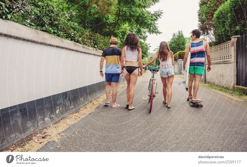 Back view of young people walking along road Lifestyle Joy Happy Leisure and hobbies Vacation & Travel Summer Sports Woman Adults Man Friendship