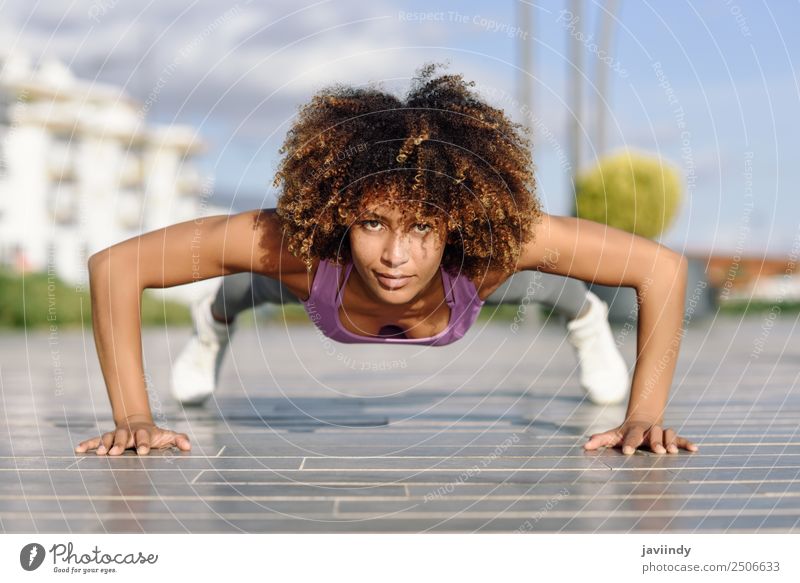Black fit woman doing pushups on urban floor Lifestyle Body Hair and hairstyles Leisure and hobbies Sports Work and employment Young woman Youth (Young adults)