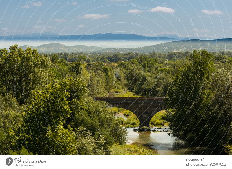 Natural stone bridge in the landscape Nature Landscape Water Sky Clouds Horizon Summer Beautiful weather Plant Tree Mountain River bank Bridge Blue Brown Gray