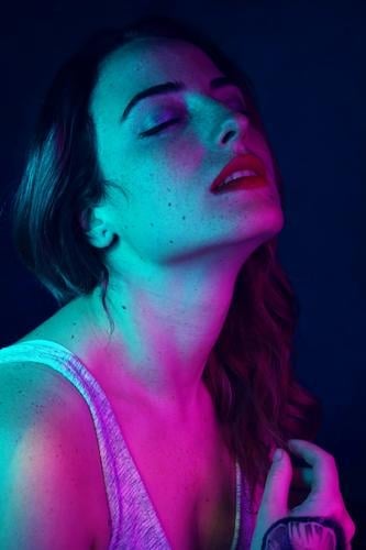 Beautiful young woman illuminated by colored lights Elegant Style Design Skin Face Freckles Harmonious Senses Human being Feminine Young woman