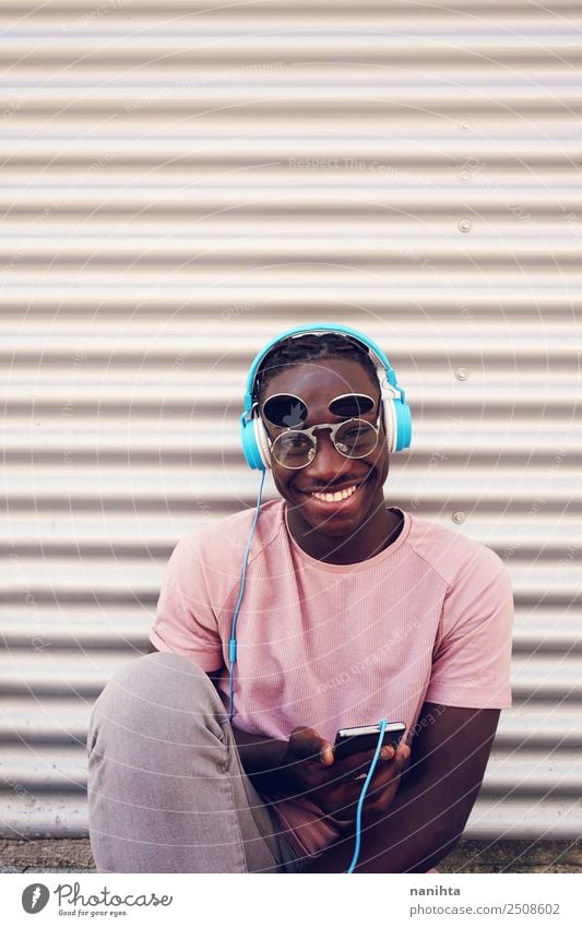 Young black man listening to music Lifestyle Style Leisure and hobbies Cellphone Headset Headphones Technology Entertainment electronics Human being Masculine