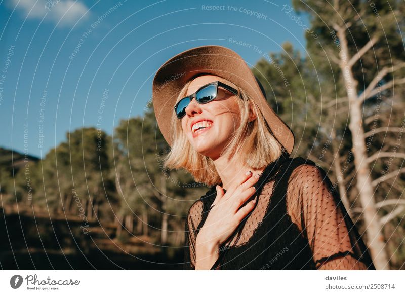 Happy blonde woman with sunglasses and a hat enjoying the sun in nature Lifestyle Elegant Style Joy Beautiful Relaxation Vacation & Travel Freedom Human being