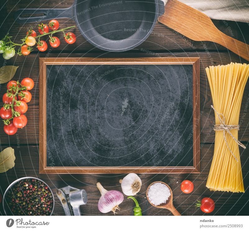 black frame and ingredients for pasta Vegetable Dough Baked goods Pan Blackboard Fresh Large Long Above Yellow Red Colour Tradition Spaghetti food Tomato Cherry