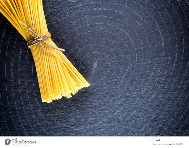 spaghetti tied with a rope Dough Baked goods Lunch Rope Line Fresh Large Long Above Yellow Black Colour Tradition Spaghetti pasta food background Raw Italian