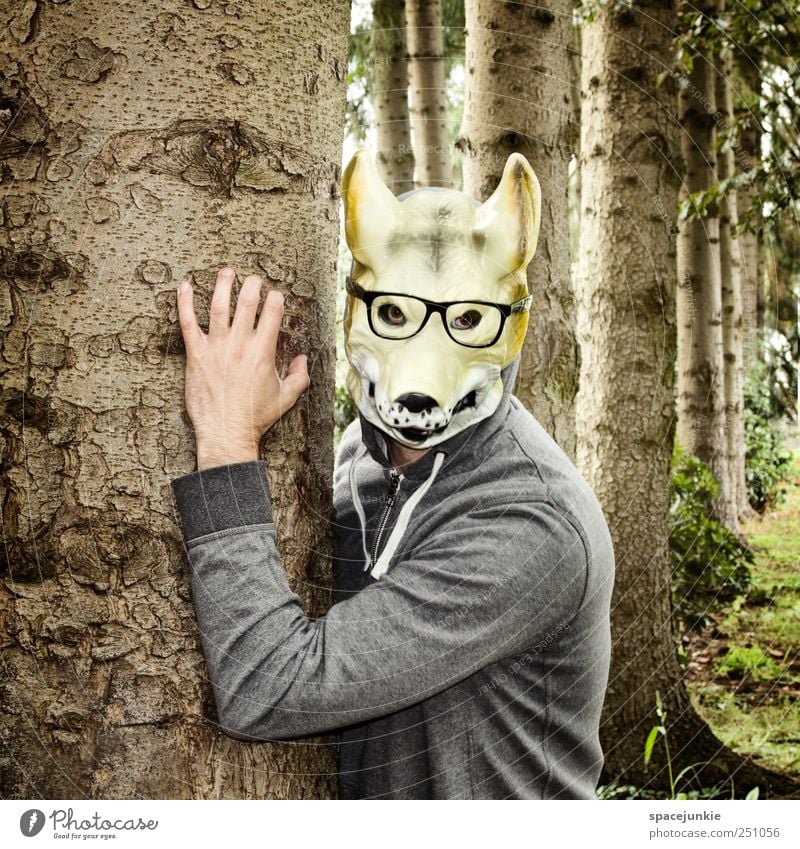 The man with the wolf mask Human being Man Adults 1 Environment Nature Beautiful weather Tree Grass Bushes Garden Forest Observe Brown Evil Wolf Animal face